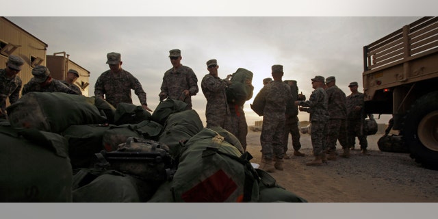 U.S. Army soldiers from 1st Cavalry Division, based at Fort Hood, Texas, load their baggage as they begin their journey home after a deployment in Iraq, at Camp Virginia, Kuwait, Thursday, Dec. 15, 2011.