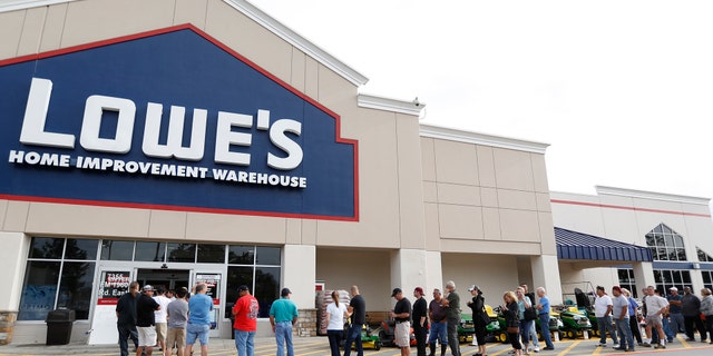 People line up to go into the Lowe's as they tried to gather supplies after rains and floods from Tropical Storm Harvey started to subside, Wednesday, Aug. 30, 2017, in Atascocita, Texas.