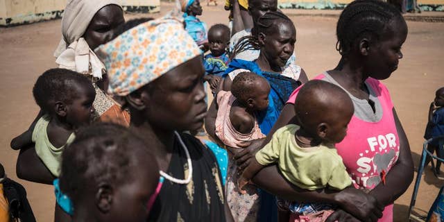 In this photo taken Monday, March 13, 2017, mothers hold their children as they wait to have them screened for malnutrition at a UNICEF-supported Outpatient Therapeutic Program in Aweil, South Sudan.