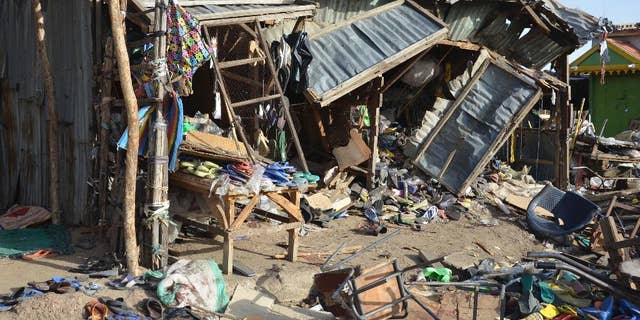 FILE- In this Monday, June 22, 2015 file photo, debris at the site of a suicide bomb attack at a market in Maiduguri, Nigeria. A teenage girl strapped with explosives ran away from a crowded mosque this week, killing only herself and cementing suspicions that Boko Haram is using unwilling captives in its terror campaign in northeast Nigeria. The girl took off after her companion blew up in an explosion that killed 30 people on Monday in Maiduguri, the biggest city in northeast Nigeria, witnesses and a mortuary worker said. (AP Photo/Jossy Ola, File)