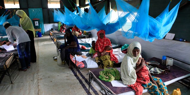 July 11, 201: Somali parents care for their young children who are being treated for malnutrition at a Doctors Without Borders (Medecins Sans Frontieres) hospital in Dagahaley Camp, Dadaab, Kenya.