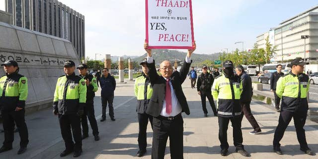 A South Korean protester holds up a placard opposing a plan to deploy the advanced U.S. missile defense system called Terminal High-Altitude Area Defense, or THAAD, near U.S. Embassy in Seoul, South Korea, Thursday, April 27, 2017. In a defiant bit of timing, South Korea announced Wednesday that key parts of a contentious U.S. missile defense system had been installed a day after rival North Korea showed off its military power. (AP Photo/Ahn Young-joon)