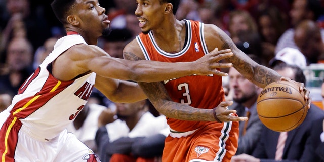 Miami Heat guard Norris Cole, left, defends against Milwaukee Bucks guard Brandon Jennings during the first half of an NBA basketball game, Tuesday, April 9, 2013, in Miami. (AP Photo/Wilfredo Lee)