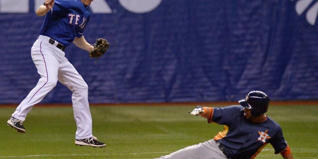 Texas Rangers' Josh Wilson, left, leaps to catch the ball as Houston Astros' Marwin Gonzalez slides safely into second base during a spring exhibition baseball game on Saturday, March 29, 2014, in San Antonio. (AP Photo/Darren Abate)