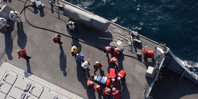 U.S. military personnel prepare to transfer an injured on board USS Fitzgerald