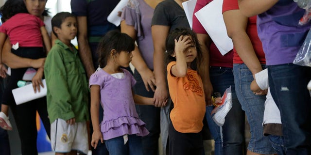 FILE - In this June 20, 2014 file photo, immigrants who entered the U.S. illegally stand in line for tickets at the bus station after they were released from a U.S. Customs and Border Protection processing facility in McAllen, Texas. Tackling what he has called a humanitarian crisis, President Barack Obama on Tuesday, July 8, 2014 asked Congress for $3.7 billion to cope with a tide of minors from Central America who are illegally crossing the U.S. border, straining immigration resources and causing a political firestorm in Washington. (AP Photo/Eric Gay, File)