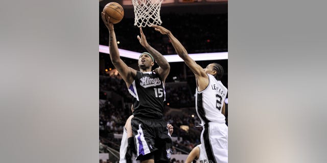 Sacramento Kings' DeMarcus Cousins, left, shoots against San Antonio Spurs' Kawhi Leonard during the second half of an NBA basketball game, Friday, April 12, 2013, in San Antonio. San Antonio won 108-101. (AP Photo/Darren Abate)