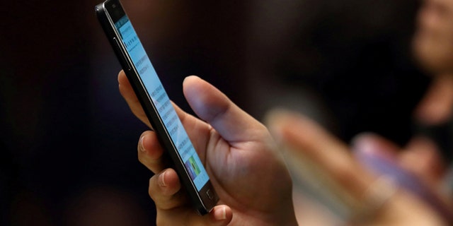 Person looking at smartphone. (REUTERS/SeongJoon Cho/Pool)