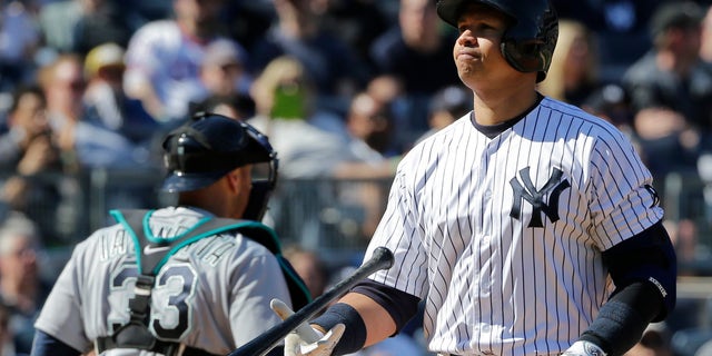 New York Yankees' Alex Rodriguez flips his bat after striking out during the sixth inning of a baseball game as Seattle Mariners catcher Chris Iannetta (33) walks toward the dugout Saturday, April 16, 2016, in New York. (AP Photo/Frank Franklin II)