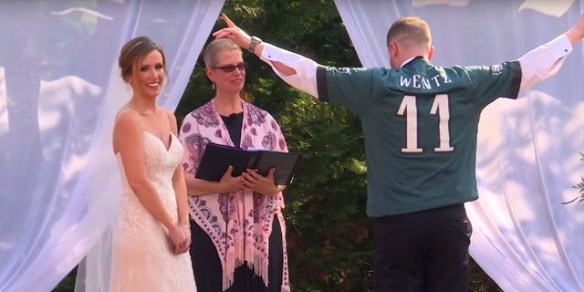 The crowd briefly cheered as Hanks donned the jersey — and the wedding DJ played the Eagles chant over the sound system.