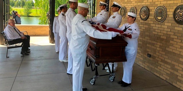 U.S. Navy pallbearers seen folding the flag for sailor Wallace Eakes.