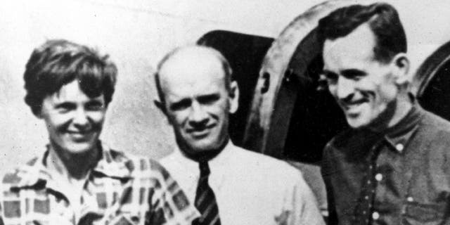 FILE - In this file photo taken on or about July 2, 1937, American aviator Amelia Earhart, left, and her navigator, Fred Noonan, right, pose beside their plane with gold miner F.C. Jacobs at Lae, New Guinea just before Earhart and Noonan took off in a flight to Howland Island on July 2, during which they disappeared somewhere in the Pacific. (AP Photo, File)
