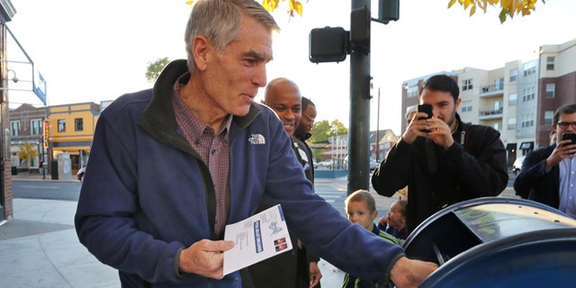 FILE: Oct. 20, 2014: Sen. Mark Udall, D-Colo., mails his ballot, in the Five Points area of Denver. Colo.