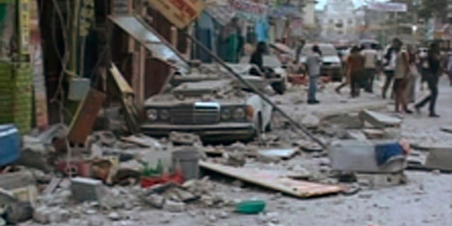 A car damaged after an earthquake struck is seen in Port-au-Prince in this January 12, 2010 video grab. A major earthquake hit impoverished Haiti on Tuesday, toppling buildings in the capital Port-au-Prince, burying residents in rubble and causing many deaths and injuries, witnesses in the city said.