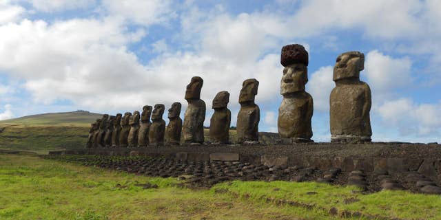 A restored statue platform with standing moai on the south coast of Rapa Nui. Note that one of the moai is adorned with a red scoria pukao. (Sean Hixon)