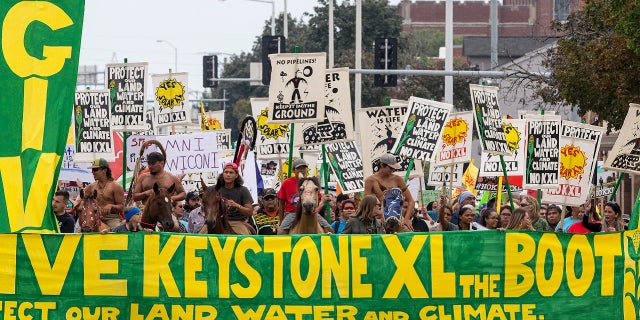 Demonstrators against the Keystone XL pipeline march in Lincoln, Neb., Aug. 6, 2017.