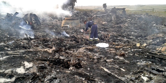 July 17, 2014: An Emergencies Ministry member works at the site of a Malaysia Airlines Boeing 777 plane crash in the settlement of Grabovo in the Donetsk region.