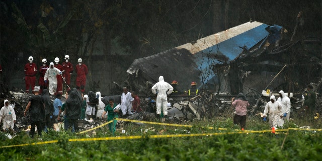 Rescue teams search through the wreckage site of a Boeing 737 that plummeted into a field with more than 100 passengers on board in Havana, Cuba on Friday.