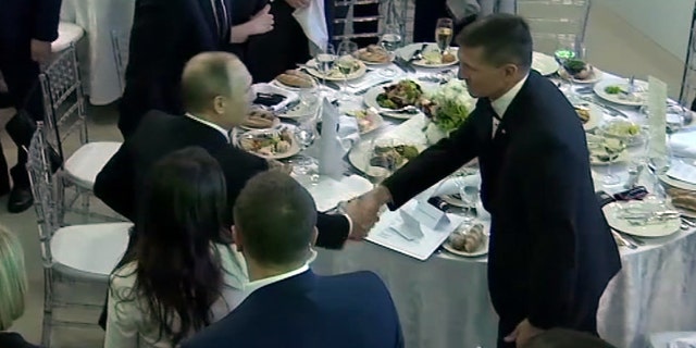 In this image made from a video taken on Dec. 10, 2015 and made available on Tuesday, Feb. 14, 2017, US President Donald Trump's former National Security Advisor Michael Flynn, right, shakes hands with Russian President Vladimir Putin, in Moscow. Flynn, who resigned following reports that he misled White House officials about his contacts with Russia, was seen attending the 10th anniversary of the Russian television network RT in 2015 where Russian President Vladimir Putin gave a speech. A US official has told The Associated Press that Flynn was in frequent contact with Ambassador Sergey Kislyak on the day the Obama administration imposed sanctions on Russia after US intelligence reported that Russia had interfered with the US elections. (Ruptly via AP)