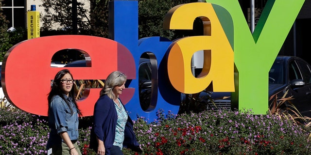 Oct. 17, 2012: In this file photo, two women walk in front of an eBay sign at the company's headquarters in San Jose, Calif.