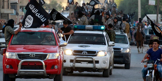 June 30, 2014: Militant Islamist fighters waving flags, travel in vehicles as they take part in a military parade along the streets of Syria's northern Raqqa province. The fighters held the parade to celebrate their declaration of an Islamic "caliphate" after the group captured territory in nearby Iraq, a monitoring service said.