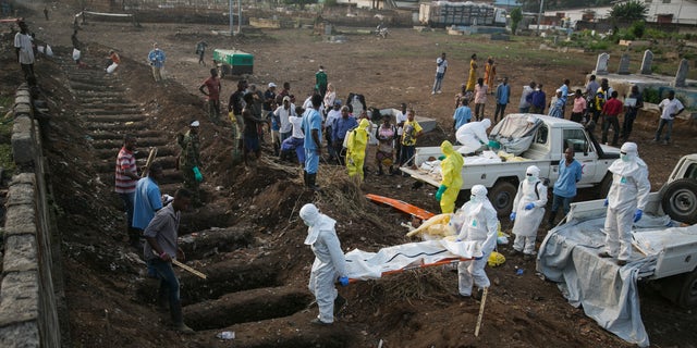 Health workers carry the body of an Ebola victim for burial at a cemetery in Freetown December 17, 2014.