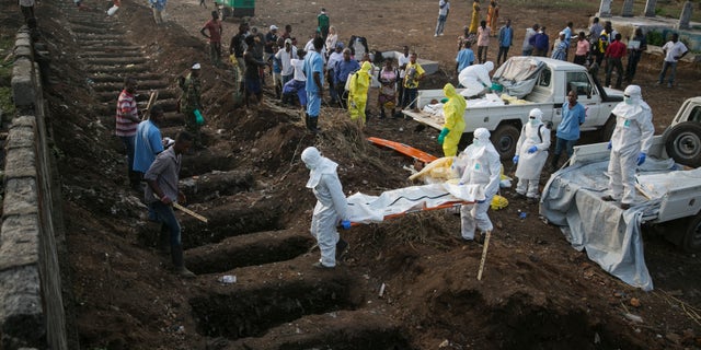 Health workers carry the body of an Ebola victim for burial at a cemetery in Freetown December 17, 2014.