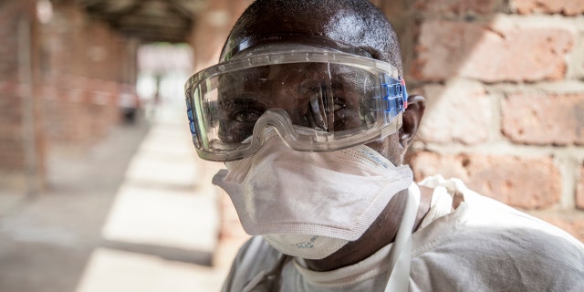 In this photo taken Saturday, May 12, 2018, a health worker wears protective clothing outside an isolation ward to diagnose and treat suspected Ebola patients, at Bikoro Hospital in Bikoro, the rural area where the Ebola outbreak was announced last week, in Congo.