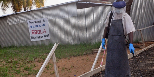 Jan. 30, 2015: A health care worker sprays disinfectant outside a USAID-funded Ebola clinic in Monrovia, Liberia.