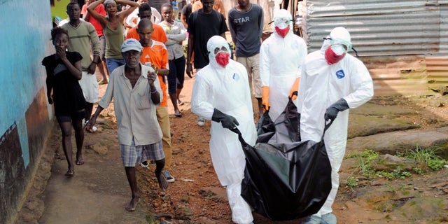 Health workers remove the body of Prince Nyentee, a 29-year-old man whom local residents said died of Ebola virus in Monrovia September 11, 2014. REUTERS/James Giahyue