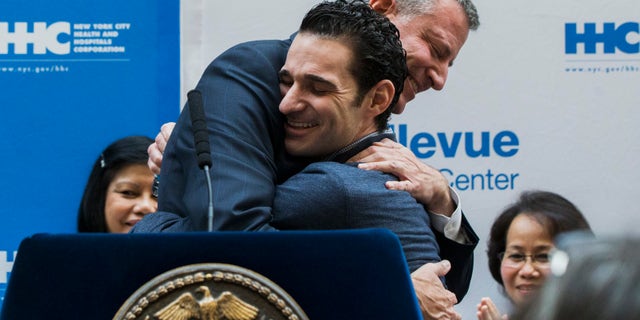 New York Mayor Bill de Blasio hugs Dr. Craig Spencer as he is discharged from Bellevue Hospital, after being stricken by Ebola, in New York November 11, 2014. REUTERS/Lucas Jackson