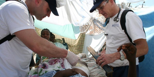 In this Jan. 16, 2010 photo provided by the International Medical Corps, Dr. Robert Fuller, right, joins Dr. Matthew Howell as they care for a person injured in the 2010 earthquake in Port-ua-Prince, Haiti. AP Photo/International Medical Corps, Margaret Aguirre