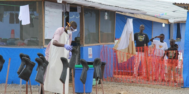 Boys Solomon (C, rear) and Joe (R, rear) stand in the "red zone" where they are being treated for Ebola at the Bong County Ebola Treatment Unit about 200 km (120 miles) east of the capital, Monrovia, October 28, 2014.  REUTERS/Michelle Nichols