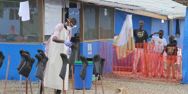Boys Solomon (C, rear) and Joe (R, rear) stand in the "red zone" where they are being treated for Ebola at the Bong County Ebola Treatment Unit about 200 km (120 miles) east of the capital, Monrovia, October 28, 2014. REUTERS/Michelle Nichols
