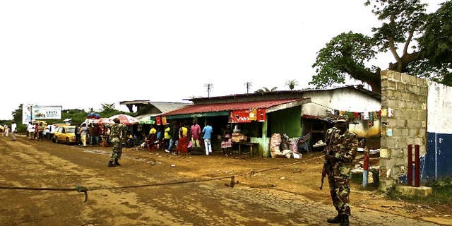 Soldiers from the Liberian army monitor a border checkpoint as part of Operation White Shield to control the Ebola outbreak, at an entrance to Bomi County in northwestern Liberia August 11, 2014. CREDIT: REUTERS/SABRINA KARIM