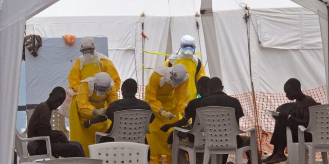 Health workers, attend to patients that contracted the Ebola virus, at a clinic in Monrovia, Liberia, Monday, Sept. 8, 2014. (AP Photo/Abbas Dulleh)