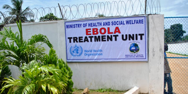 A man stands at the gate of an Ebola virus treatment center in Monrovia September 21, 2014. REUTERS/James Giahyue