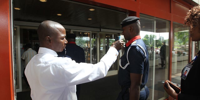 A security personnel screens a man's temperature at the entrance of Transcorp Hilton hotel in Abuja September 3, 2014. REUTERS/Afolabi Sotunde
