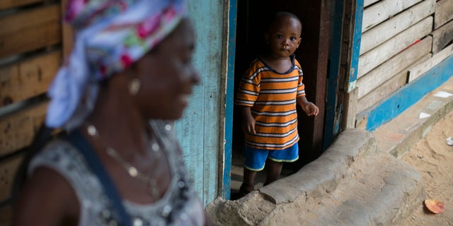 A Sierra Leonean boy looks out of a doorway in Freetown, Sierra Leone, December 16, 2014. REUTERS/Baz Ratner