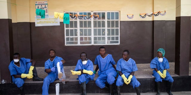 Health workers rest outside a quarantine zone at a Red Cross facility in the town of Koidu, Kono district in Eastern Sierra Leone December 19, 2014. REUTERS/Baz Ratner