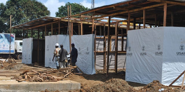 Men work at the construction site of a new Ebola treatment center in Monrovia, Liberia, September 26, 2014. REUTERS/James Giahyue