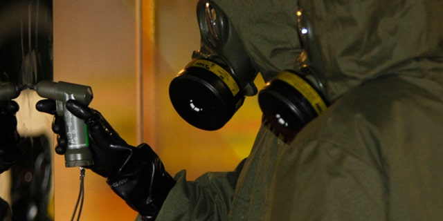 A Hazmat crew checks a stain on the wall at Kuala Lumpur International Airport 2 in Sepang, Malaysia on Sunday, Feb. 26, 2017. Malaysian police order a sweep of Kuala Lumpur airport for toxic chemicals and other hazardous substances following the killing of Kim Jong Nam. (AP Photo/Daniel Chan)