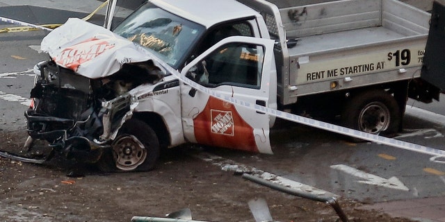 Police tape rests on a damaged Home Depot truck sits after a motorist drove onto a bike path near the World Trade Center memorial, striking and killing several people Tuesday, Oct. 31, 2017, in New York. (AP Photo/Bebeto Matthews)