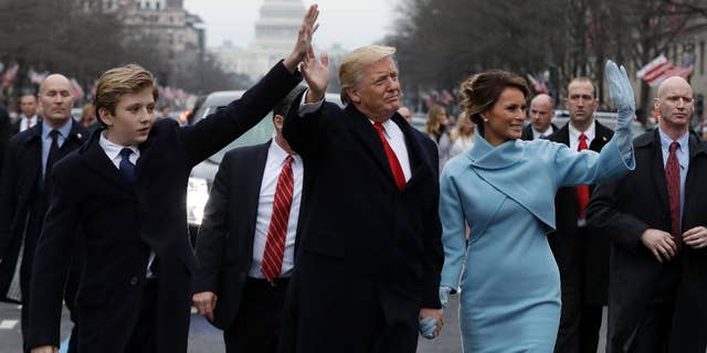 FILE - In this Jan. 20, 2017, file photo, President Donald Trump waves as he walks with first lady Melania Trump and their son Barron during the inauguration parade on Pennsylvania Avenue in Washington. Think it’s tough to be a kid? Try being a “first kid” - the child of an American president. (AP Photo/Evan Vucci, File)