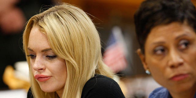 July 6: Lindsay Lohan (left) sits in court with her lawyer Shawn Chapman Holley, before a judge sentenced her to 90 days in jail and 90 days in an in-patient rehab facility.