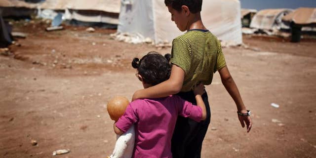 Syrian children walk in the Bab al-Salam refugee camp in Azaz on July 15, 2013