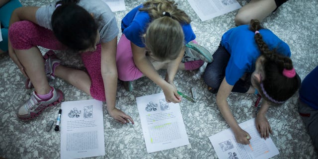 NAZARETH-ILIT, ISRAEL - MAY 27 : Israeli schoolchildren do classwork while in a bomb shelter at their school during the Home Front drill "Turning Point 7" on May 27, 2013 in Nazareth-Ilit, Israel. The nationwide exercise tests the civilian population's response to a possible massive rocket attack from three fronts. (Photo by Ilia Yefimovich/Getty Images)