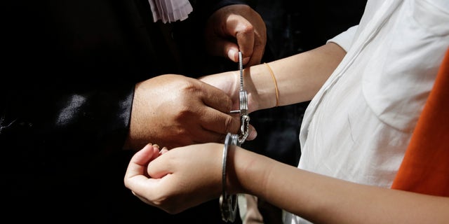 DENPASAR, BALI, INDONESIA - JANUARY 14: An officer opens the handcuffs of Heather Mack of the US as she arrive in a cell after her hearing trial on January 14, 2015 in Denpasar, Bali, Indonesia. Heather Mack and her boyfriend Tommy Schaefer are accused of murdering Mack's mother, Sheila von Wiese-Mack, whose body was found stuffed inside a suitcase in the back of a taxi outside a luxury Bali hotel in August 2014. (Photo by Agung Parameswara/Getty Images)