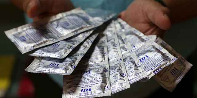 A health worker shows condoms that are given for free to the public by the Department of Health in Manila, Philippines.