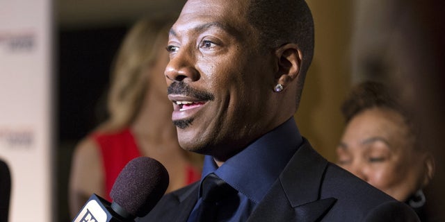 Eddie Murphy speaks to reporters as he arrives for the Mark Twain prize for Humor honoring Murphy at the Kennedy Center in Washington October 18, 2015.